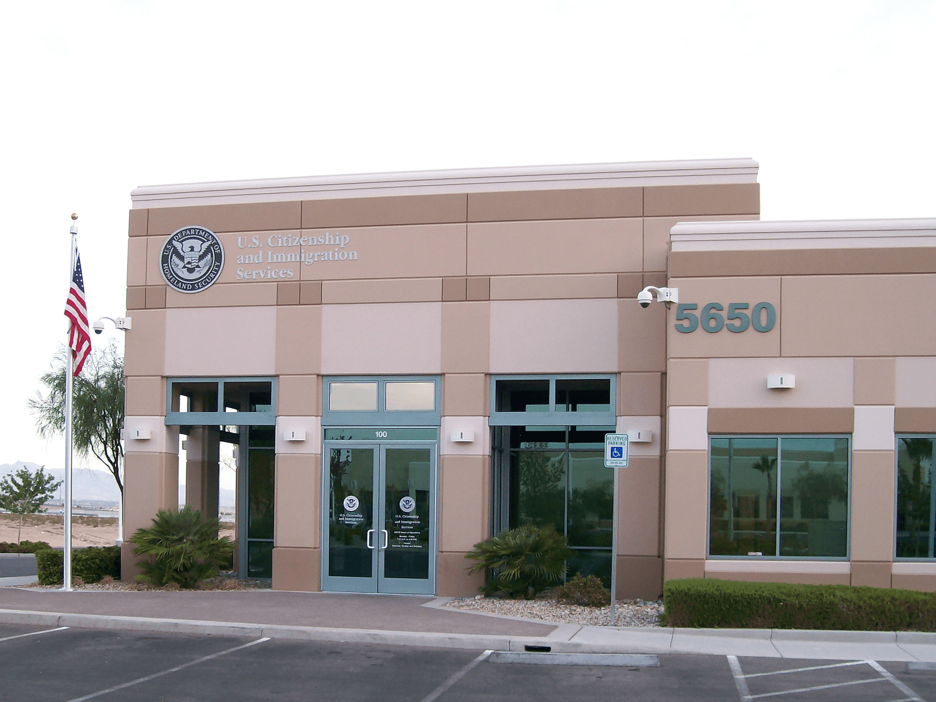 미국 이민국 네바다 필드 오피스 건물 외관, 미국 국기와 장애인 주차 표지판 포함 USCIS Nevada Field Office building exterior with American flag and accessible parking sign